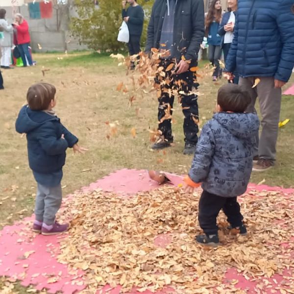 Niños jugando con hojas secas en otoño
