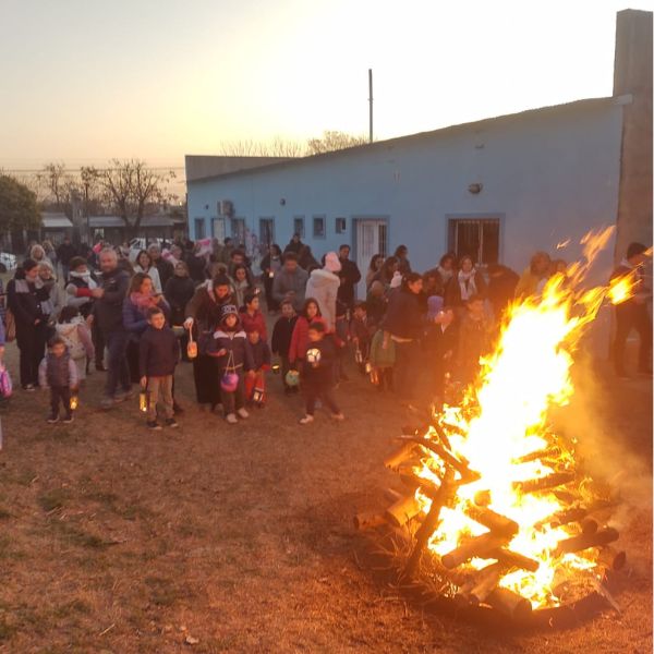 Familias junto a una fogata en la noche de los farolitos